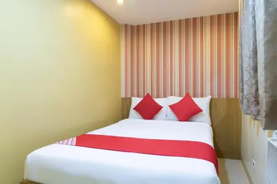 a bedroom with a white bed with red pillows at Starlight Bed and Breakfast in Manila