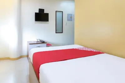 a bedroom with a bed with a red and white blanket at Starlight Bed and Breakfast in Manila