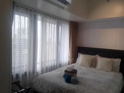 a bedroom with a bed with a suitcase on it at E & T Homecations 2 Bedroom Apartment at SMDC Air Residences in Manila