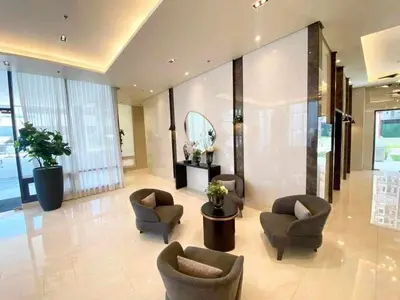 a lobby with chairs and a table and a mirror at 2BR SMDC Bloom Residences Near NAIA Wi-fi +Netflix in Manila