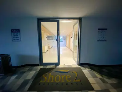 a store entrance with a sign in front of a door at Shore2 Luxurious & Homely Suite near MOA in Manila