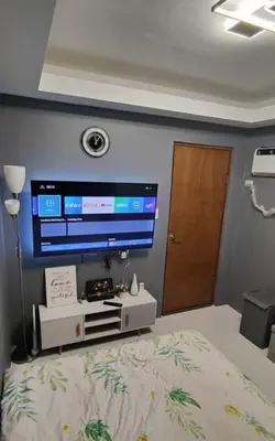 a bedroom with a large television on the wall at Sky Haven Staycation in Rizal