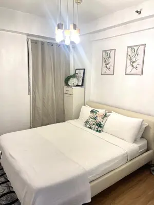 a white bedroom with a large bed in a room at 2-Bed Apartment in Near Airport Paranaque in Manila