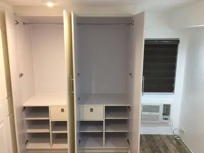 a closet with white cabinets and a window at Renovated 2br 2tb Wifi/Netflix very near Mall QC in Manila
