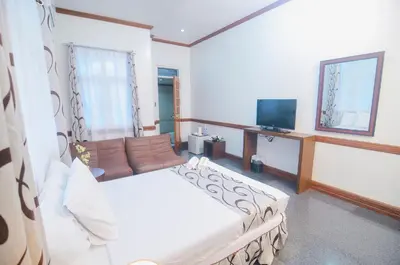 a bedroom with a large bed and a television at Villa Jhoana Resort in Angono