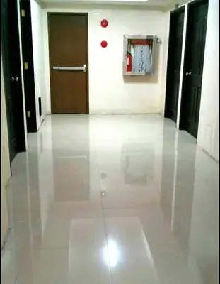 a hallway with a white floor and a brown door at Condo Premium Near NAIA T123 in Manila