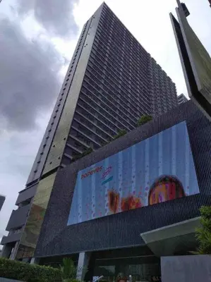 a tall building with a large billboard in front of it at Minju Staycation at Fame Residences Free Netflix & Wifi in Manila