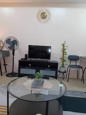 a living room with a table and a tv at studio condo building 81 newport boulevard in Manila