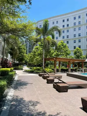 a park with benches in front of a building at studio condo building 81 newport boulevard in Manila