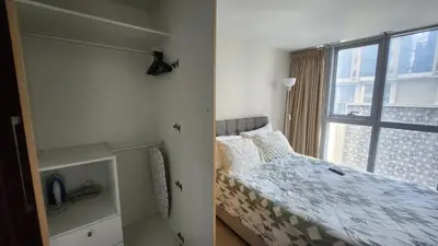 a bedroom with a bed and a window at BGC Uptown Mall Suite in Manila