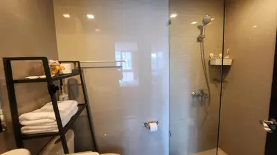 a bathroom with a shower with a glass door at BGC Uptown Mall Suite in Manila