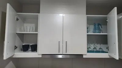 a kitchen with white cabinets with glassware in it at BGC Uptown Mall Suite in Manila