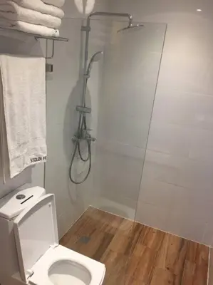 a bathroom with a shower and a toilet at Cozy35sqm w parking balcony Wifi/Netflix near Mall in Manila