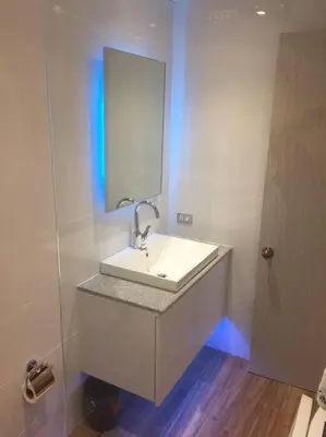 a white bathroom with a sink and a mirror at Cozy35sqm w parking balcony Wifi/Netflix near Mall in Manila