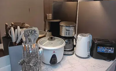 a kitchen counter with appliances on a counter top at Hawaii Suite by Guest Reservations Manila in Manila