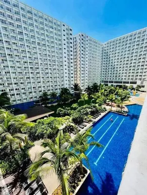 an aerial view of a large building with a swimming pool at Hawaii Suite by Guest Reservations Manila in Manila
