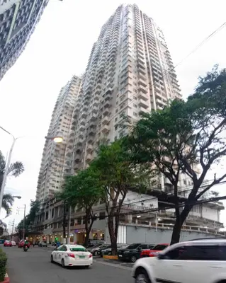 a large building with cars parked in front of it at SonSon at Manhattan Plaza Tower 1, Araneta, Cubao, Quezon City in Manila