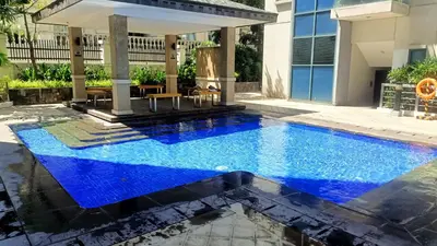 a swimming pool in the middle of a house with blue water at Hilander's Condotel near Terminal 3 Airport in Manila