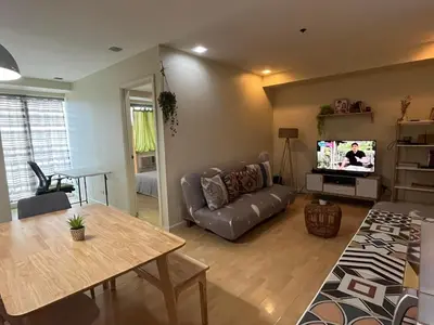 a living room with a couch and a television at SHAW BLVD 69 sqm 2 bdrm w/ WiFi, parking, across Shangrila Mall in Manila