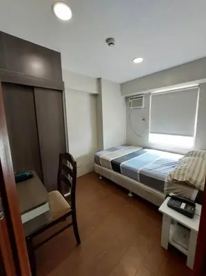 a small room with a bed and a desk at 2BR Loft unit in Manila