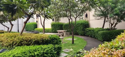 a garden with a bench and trees and bushes at Casa Antonio at Fairway Terraces Family Penthouse 2BR Wi-Fi Nr Golf, Airport, Fort BGC in Manila