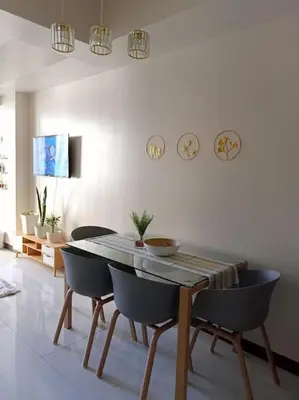 a dining table and chairs in a living room at Beautiful High End Condo in City Center, Manila in Manila