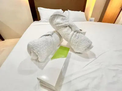 a hotel room with a bed with towels on it at Kiel 4-Star Condo Hotel Near NAIA Manila Airport Terminal in Manila