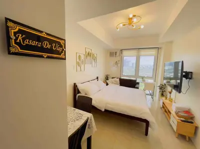 a bedroom with a king sized bed and a sign on the wall at Kasara De Ulap BEST Staycation - 25th Floor City View - Pool & Fast Wi-Fi in Manila