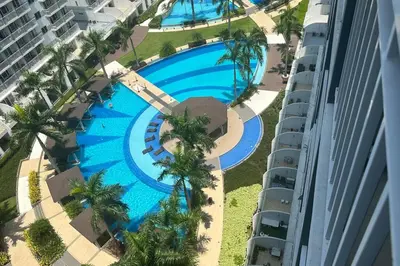 an overhead view of a swimming pool at a resort at Tropical Balcony Pool View, 14th floor, MOA, Netflix, Airport at Shell Residence in Manila