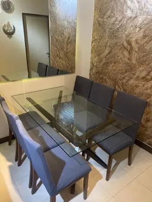 a glass dining room table with chairs and a mirror at Two Bedroom Fully Furnished 70sqm CONDO MIREA RESIDENCES PASIG in Manila