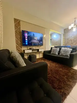 a living room with a couch and a flat screen tv at 2BHK with Balcony Fully Furnished-70sqm Condo Pasig in Manila