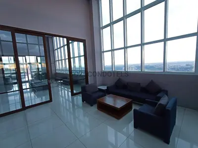 a living room with couches and a table and windows at The Beacon Makati by Cozi Condotels in Manila
