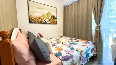 a bedroom with a bed with a quilt on it at ART's Nest at Shore Residences in Manila