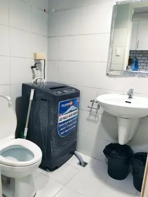 a bathroom with a toilet and a sink at Glenda Place Aurum At Sea Residences near Moa in Manila
