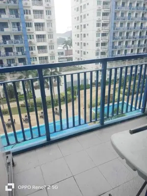 a balcony with a blue railing in a building at Glenda Place Aurum At Sea Residences near Moa in Manila