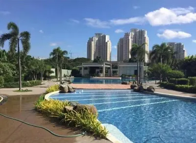 a swimming pool with a city in the background at Casa REYNA at KASARA Urban Residences in Manila