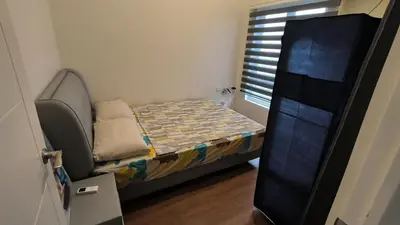 a small bedroom with a bed and a window at Prisma residence Celeste tower PH 16B with fully furnished and fast wifi for rent in Manila