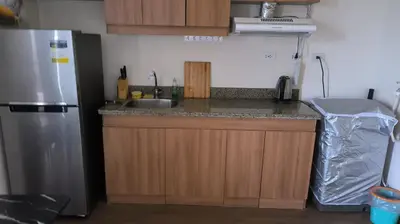 a kitchen with a sink and a refrigerator at Prisma residence Celeste tower PH 16B with fully furnished and fast wifi for rent in Manila