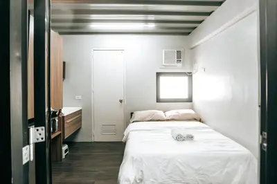 a bedroom with a bed with two towels on it at District Inn in Manila