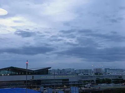 a view of a building with a city in the background at Near Terminal 3 Two Palmtree Villas- Walking distance only (JJRMK) in Manila
