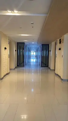 an empty hallway in a building with a white tile floor at Condo Suite/Apartment Pasay SM MOA - Stay Cozy & Boujee in Manila