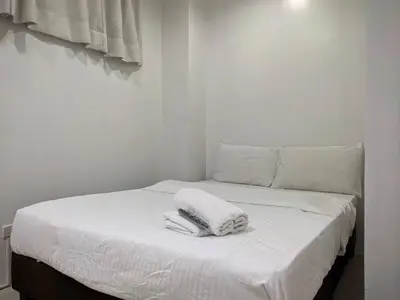 a white bed with two towels on top of it at JP Santiago Studio Makati J204 in Manila