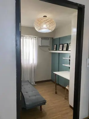 a room with a chair and a table and a light at Relax@Samaya Pasig in Manila