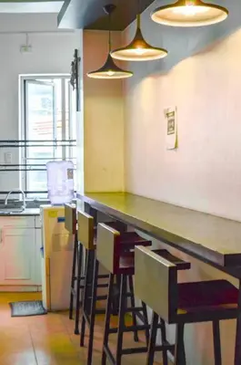 a kitchen with a counter with chairs and a table at JP Santiago Studio Makati J206 in Manila