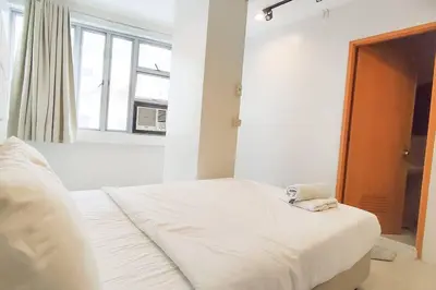 a white bed in a room with a window at JP Santiago Studio Makati J207 in Manila