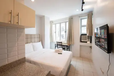 a hotel room with a white bed and a table at JP Santiago Studio Makati J208 in Manila