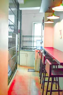 a kitchen with a red counter and chairs in it at JP Santiago Studio Makati J307 in Manila