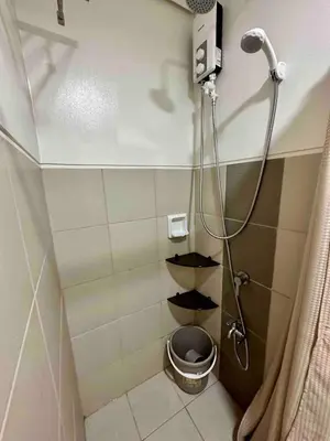 a bathroom with a shower with a toilet in it at Staycation at Spring Residences in Paranaque in Manila