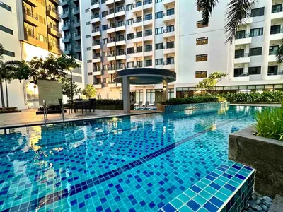 a large blue swimming pool in front of a building at Staycation at Spring Residences in Paranaque in Manila