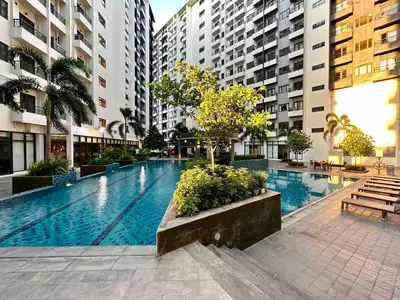 a large swimming pool in a city with buildings at Staycation at Spring Residences in Paranaque in Manila
